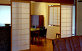 A row of sliding shoji screens separates the kitchen / dining room from the living room.